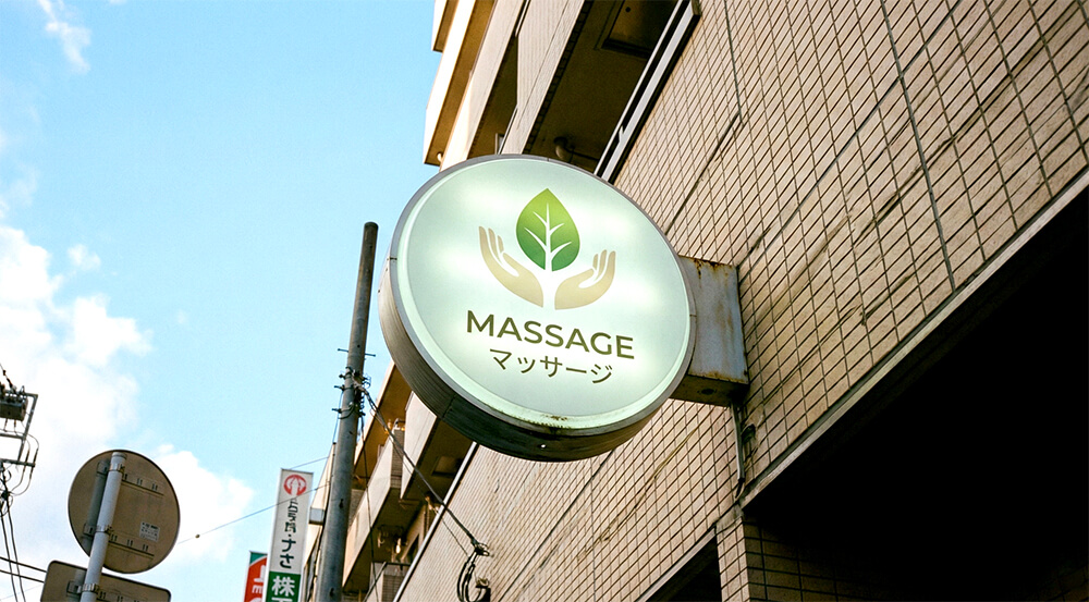 ビル壁面に設置された丸型のマッサージ店袖看板(突き出し看板)