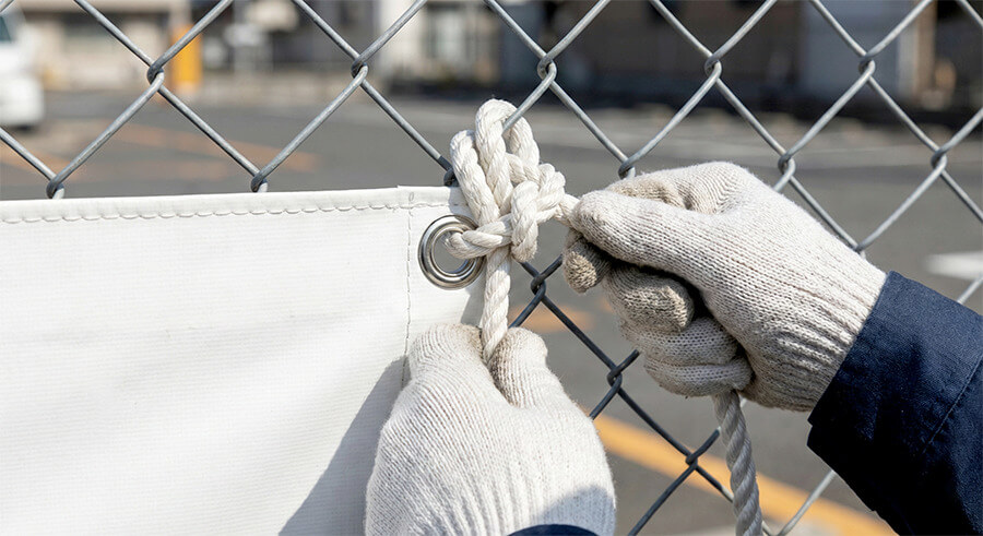 ハトメにロープを通してしっかりと結んでいる様子