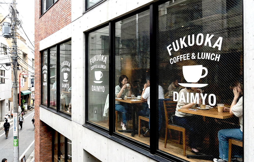 カフェの窓ガラスにおしゃれなロゴが貼られている例