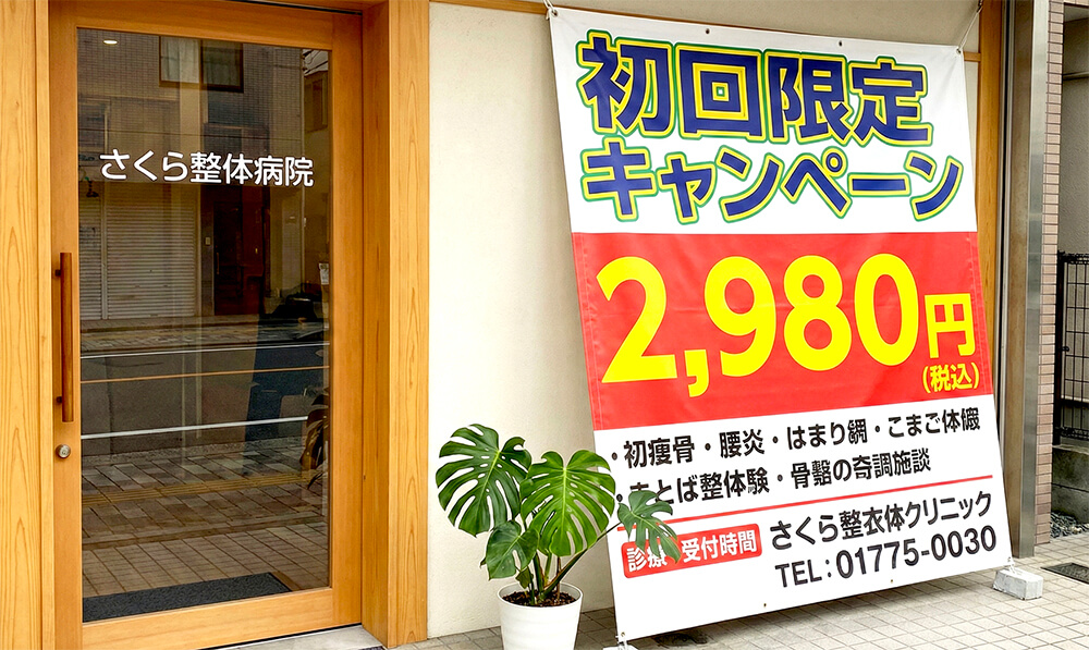 整体院の入り口横に吊るされたキャンペーン告知用の大きな布製タペストリー