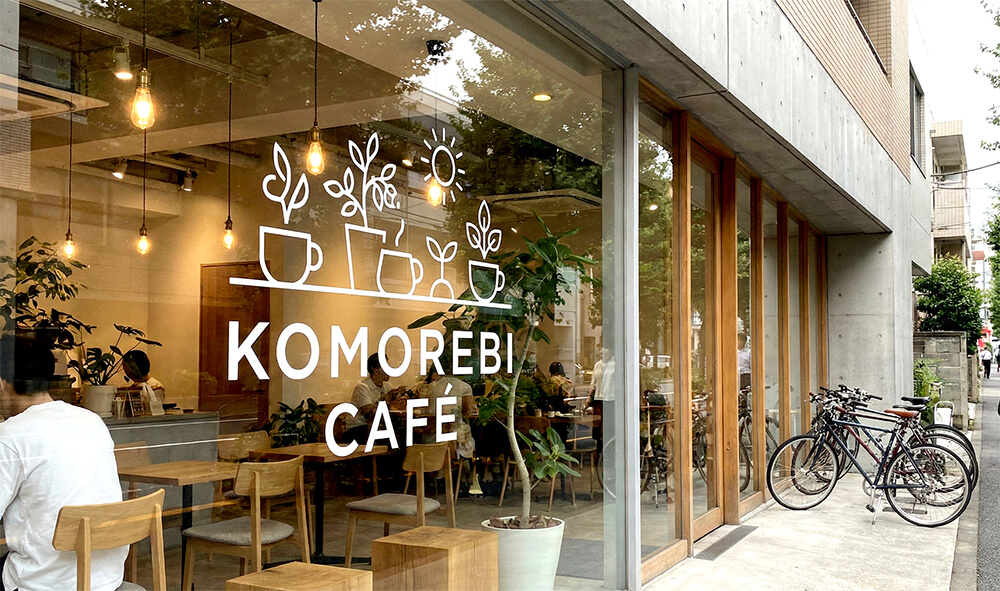 代官山のおしゃれなカフェのガラス面に、白のカッティングシートでロゴとおしゃれなイラストが装飾されている